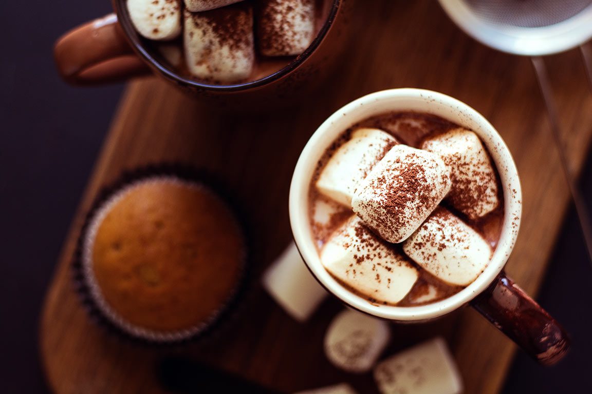 A steaming cup of hot cocoa, generously topped with fluffy marshmallows and a sprinkle of cinnamon, creates an inviting scene that could easily represent the best hot chocolate near me or the best hot chocolate in dc.