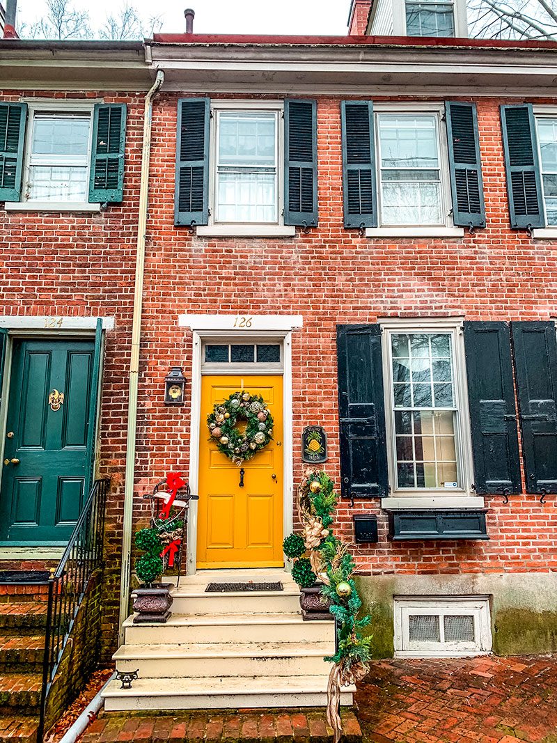 A quaint house spreading the cheer for Christmas in Wilmington Delaware and New Castle DE with decorated doors and railings!